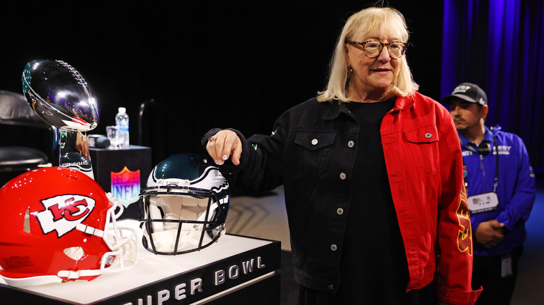 Donna Kelce posing with football helmets