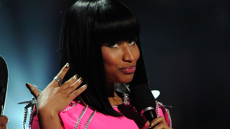 Nicki Minaj fanning herself with hand, looking up