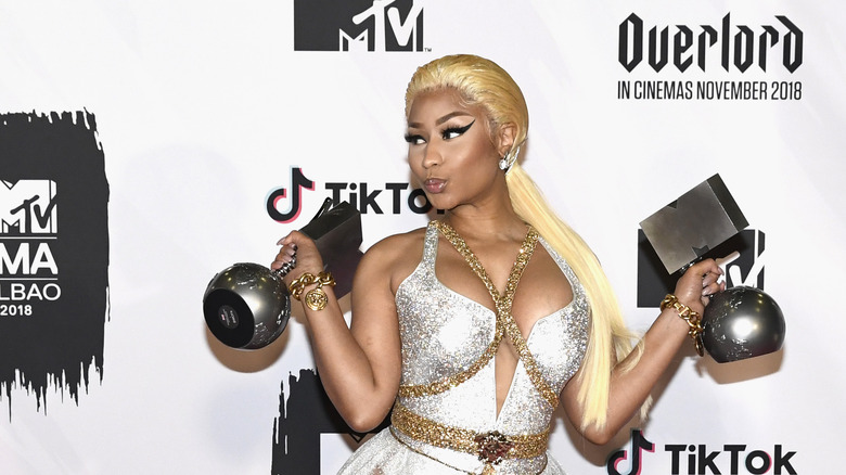 Nick Minaj holding awards, posing