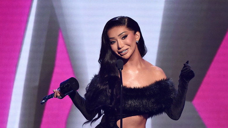 Nikita Dragun with a microphone on stage