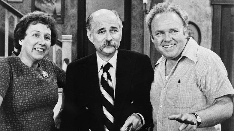 Jean Stapleton, Norman Lear and Carroll O'Conner posing together on the set of All in the Family