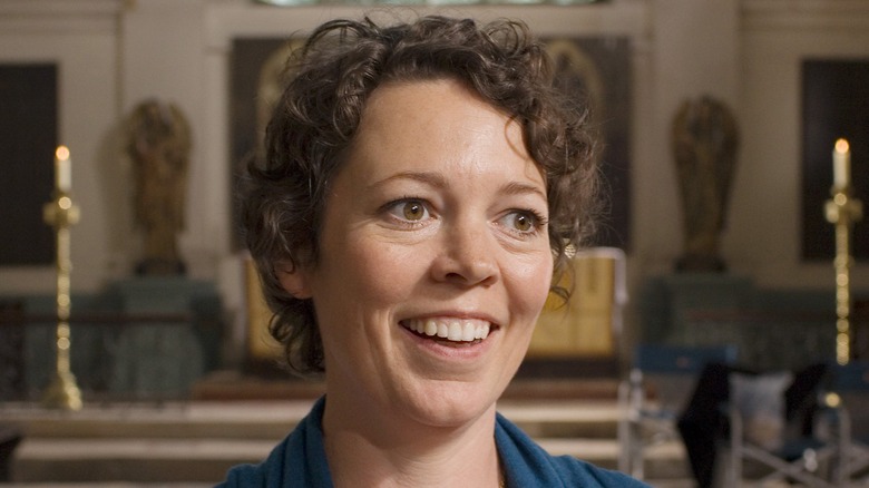 Olivia Colman smiling in a church