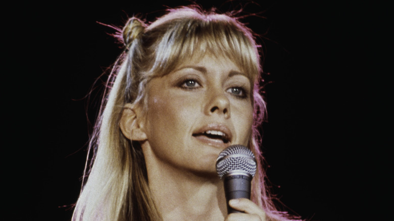 Olivia Newton-John singing into microphone