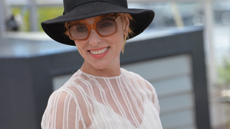 Parker Posey in black hat and shades