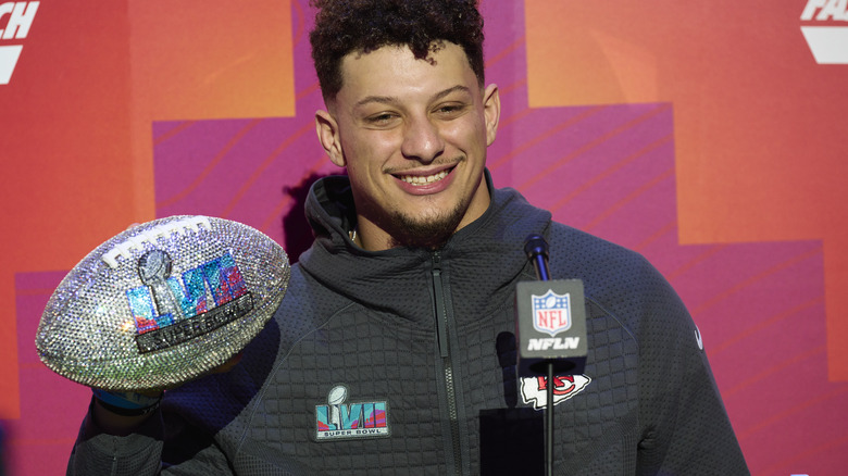 Patrick Mahomes smiling in front of microphone