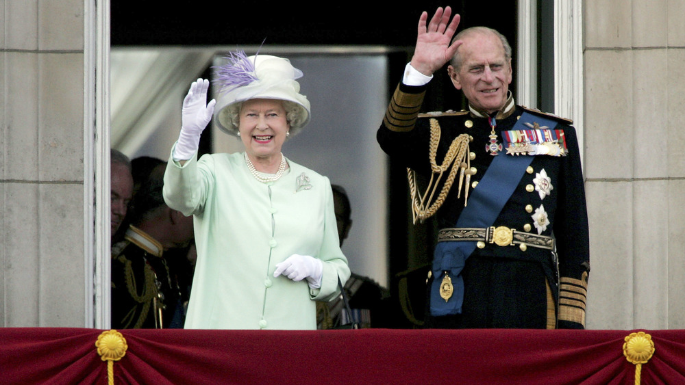 Queen Elizabeth and Prince Philip smiling and waving