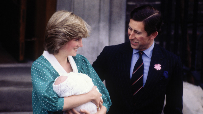 Princess Diana holding Prince William next to Prince Charles