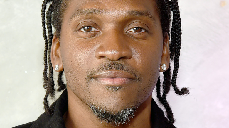 Pusha T with some gray in his beard, smiling