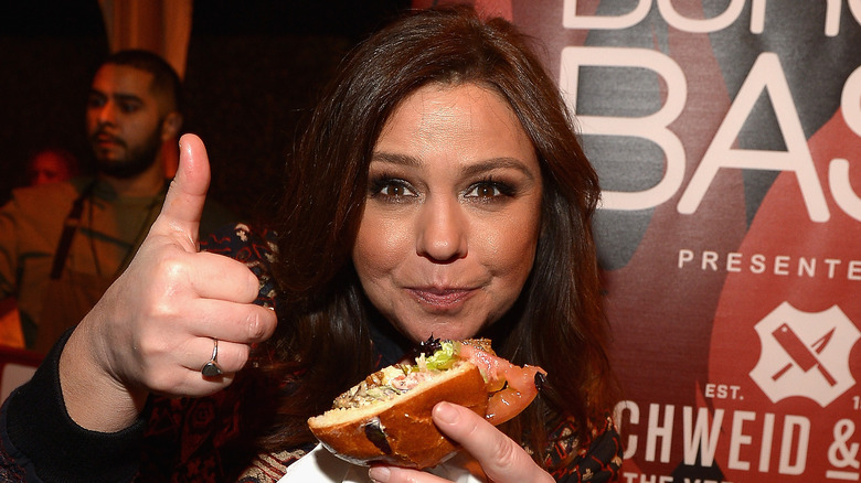 Rachael Ray holding a burger and giving a thumbs up