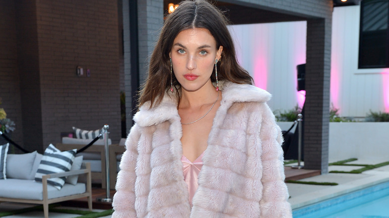 Rainey Qualley posing for cameras in fur coat