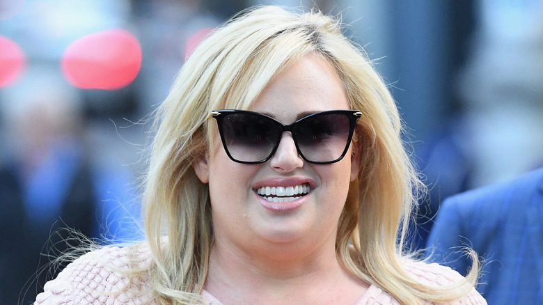 Rebel Wilson smiling and wearing sunglasses