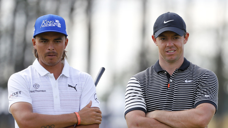 Rickie Fowler next to Rory McIlroy, looking on