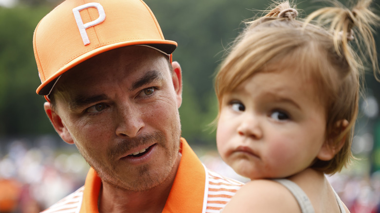 Rickie Fowler looking at his daughter