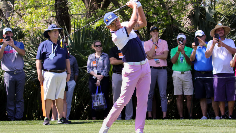 Rickie Fowler playing golf in a colorful outfit