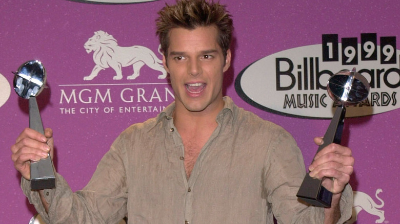 Ricky Martin posing with awards