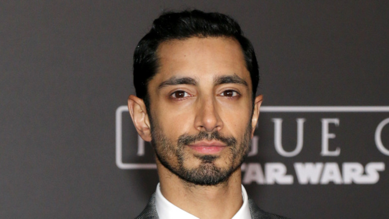 Riz Ahmed smiling slightly