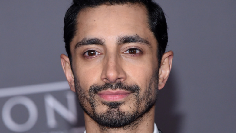 Riz Ahmed smiling slightly