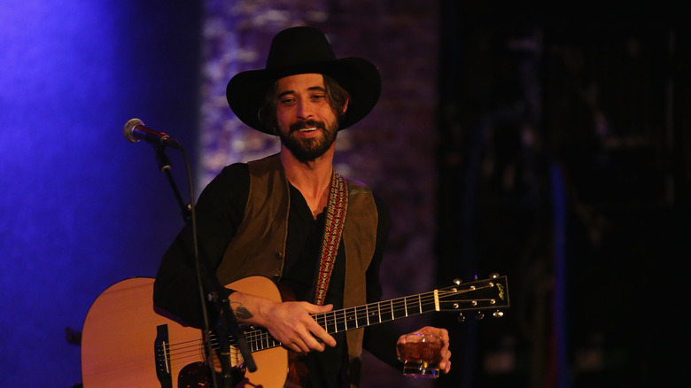 Ryan Bingham holding a guitar