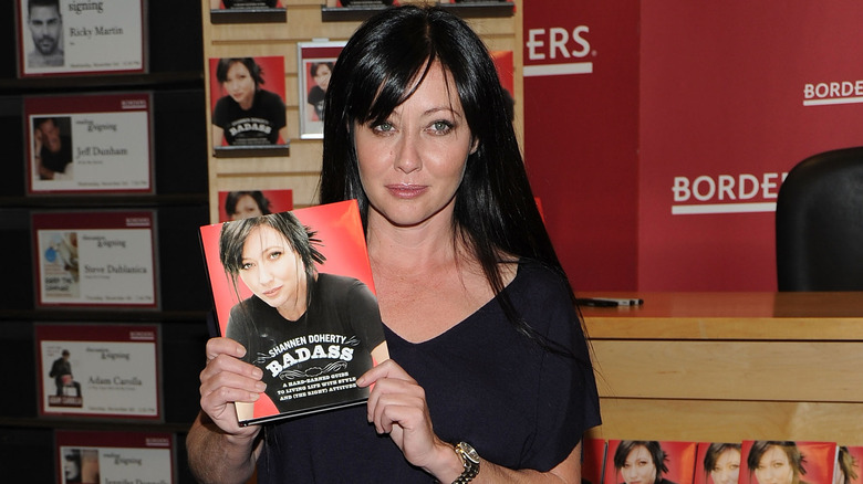Shannen Doherty holding up her book