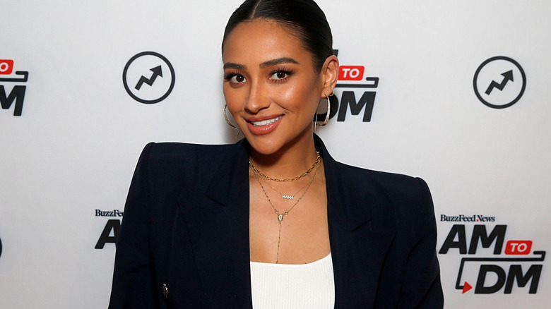 Shay Mitchell smiling in suit