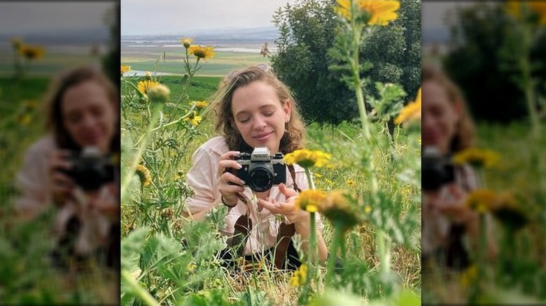 Shira Haas smiling, holding camera