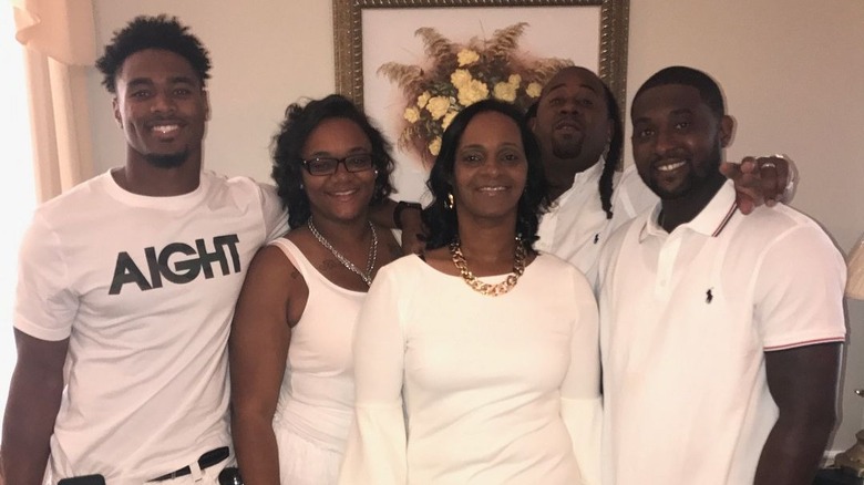 Jonathan Owens (left) wearing all white alongside his family, also wearing all white