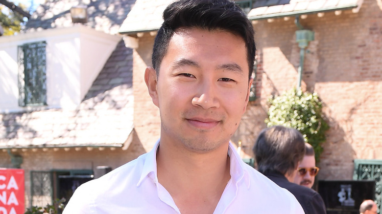 Simu Liu smiling in a white shirt