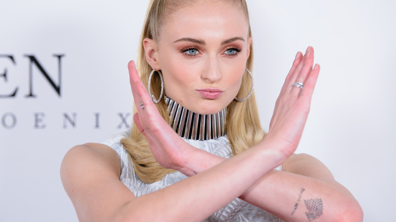 Sophie Turner crossing her arms on the red carpet