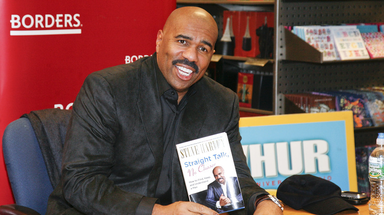 Steve Harvey posing with his book