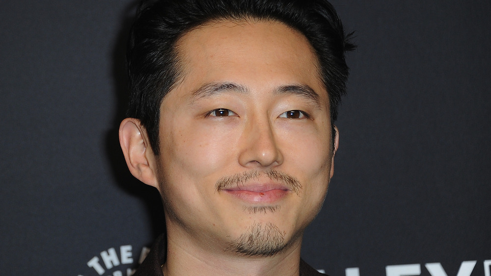 Steven Yeun smirking