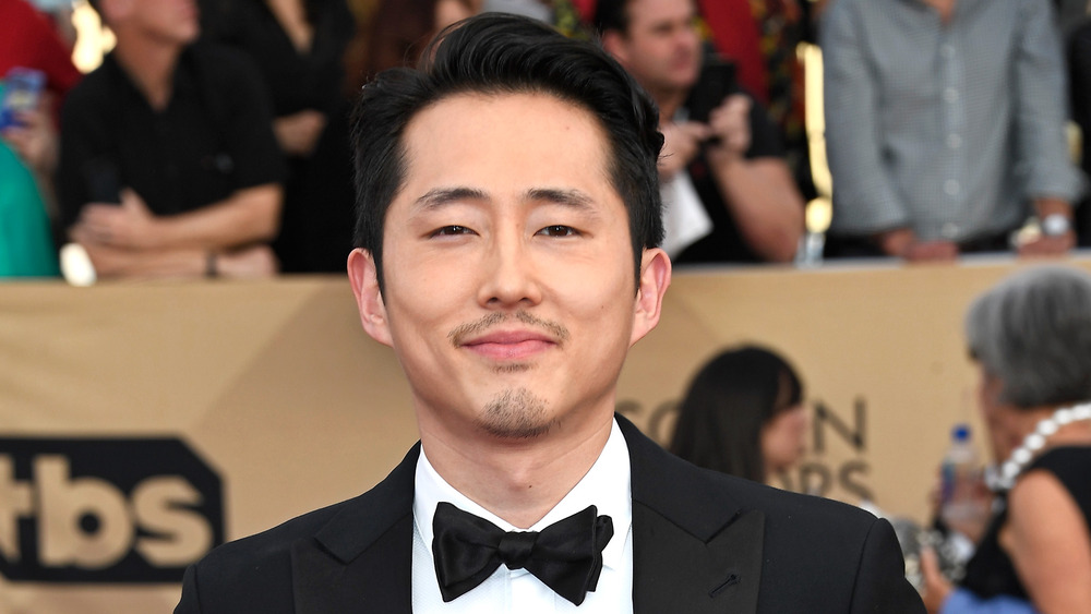 Steven Yeun smiling in a tuxedo 