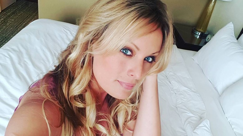 Stormy Daniels sitting on a bed