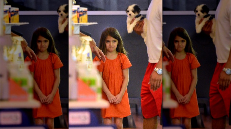 Suri Cruise making sad face at puppy