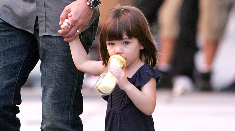 Suri Cruise drinking from bottle