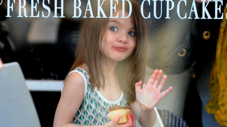 Suri Cruise holding cupcake