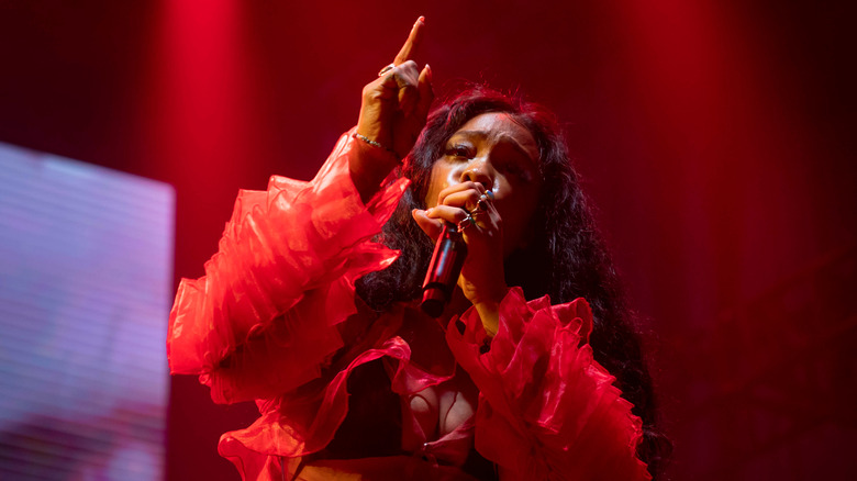 Sza holding the microphone while performing