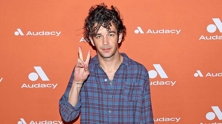 Matty Healy giving the peace sign