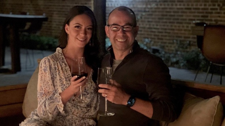 Melyssa Davies and James Murray smiling with glasses of wine