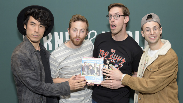 The Try Guys posing with copy of their book