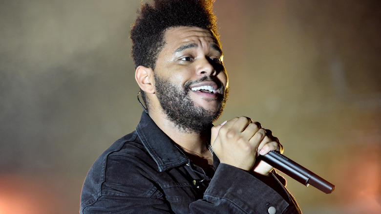 The Weeknd smiling while singing