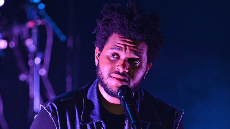 The Weeknd smiling mid-performance