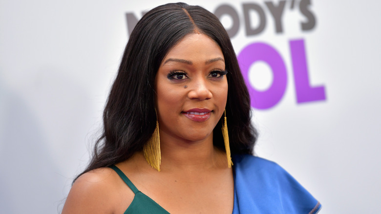 Tiffany Haddish posing in front of a step and repeat