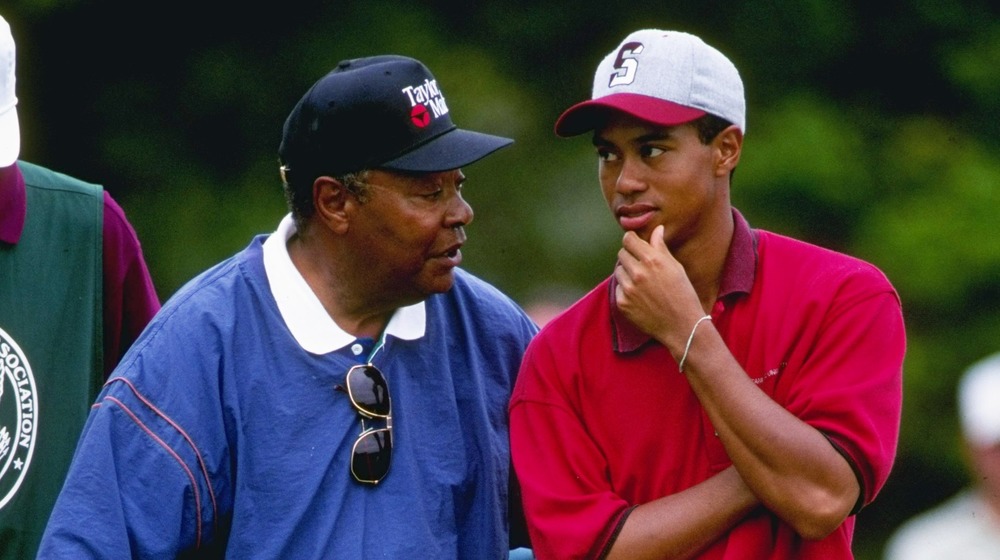 Earl Woods and Tiger Woods talking on the golf course