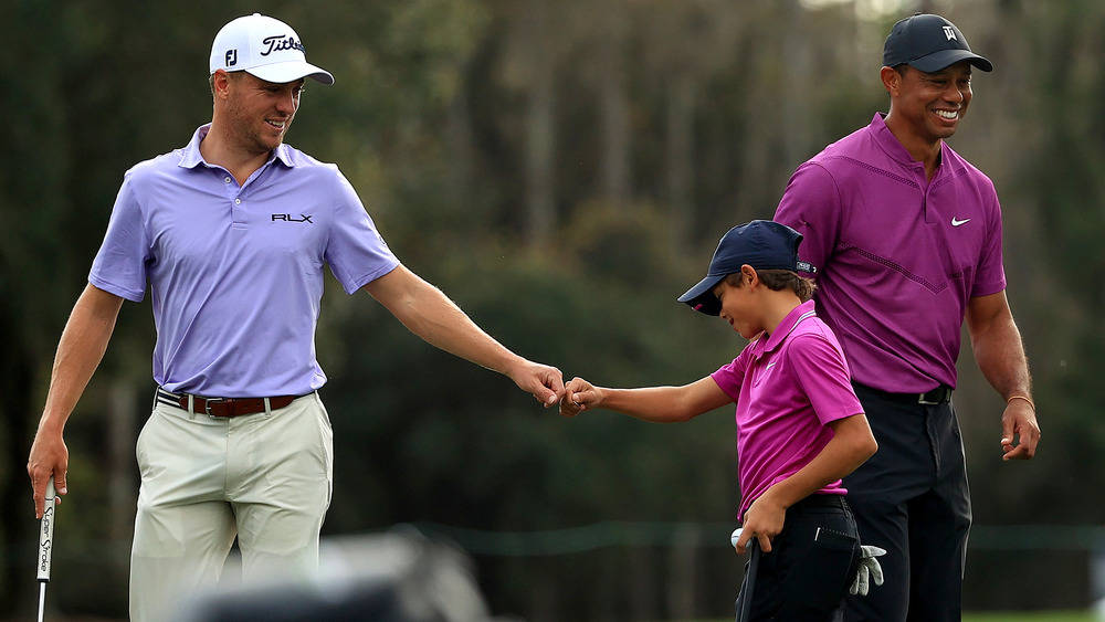 Justin Thomas with Charlie Woods and Tiger Woods