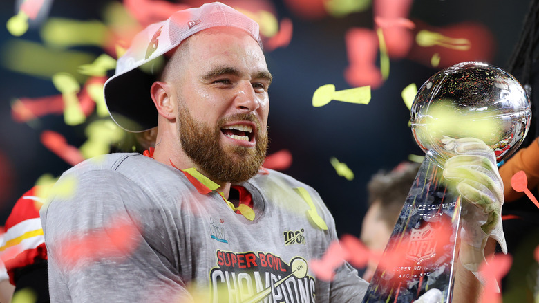 Travis Kelce holding the Vince Lombardi Trophy