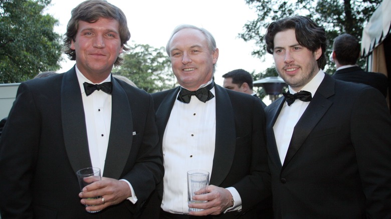 Tucker Carlson and others in class black tuxes at an outdoor party