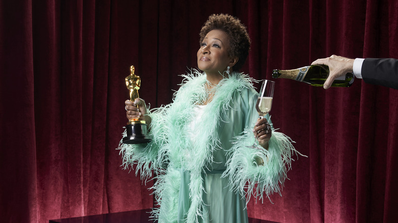 Wanda Sykes holding an Oscar and Champagne