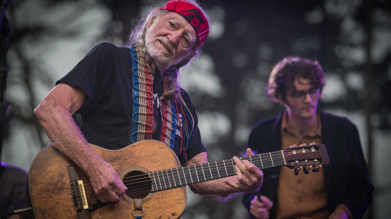 Willie Nelson playing guitar with Micah Nelson