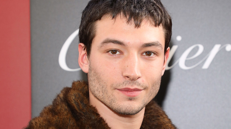 Ezra Miller fur jacket stubble posing