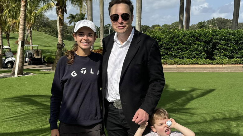 Kai Trump posing with Elon Musk on a golf course